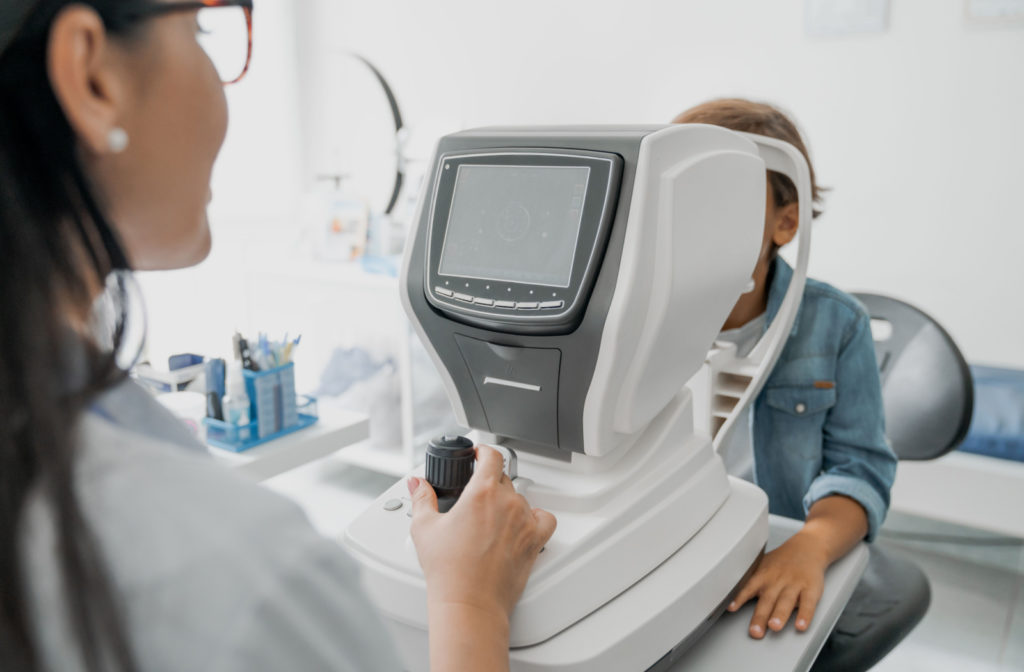 An optometrist using a medical apparatus to monitor a child's myopia progression.