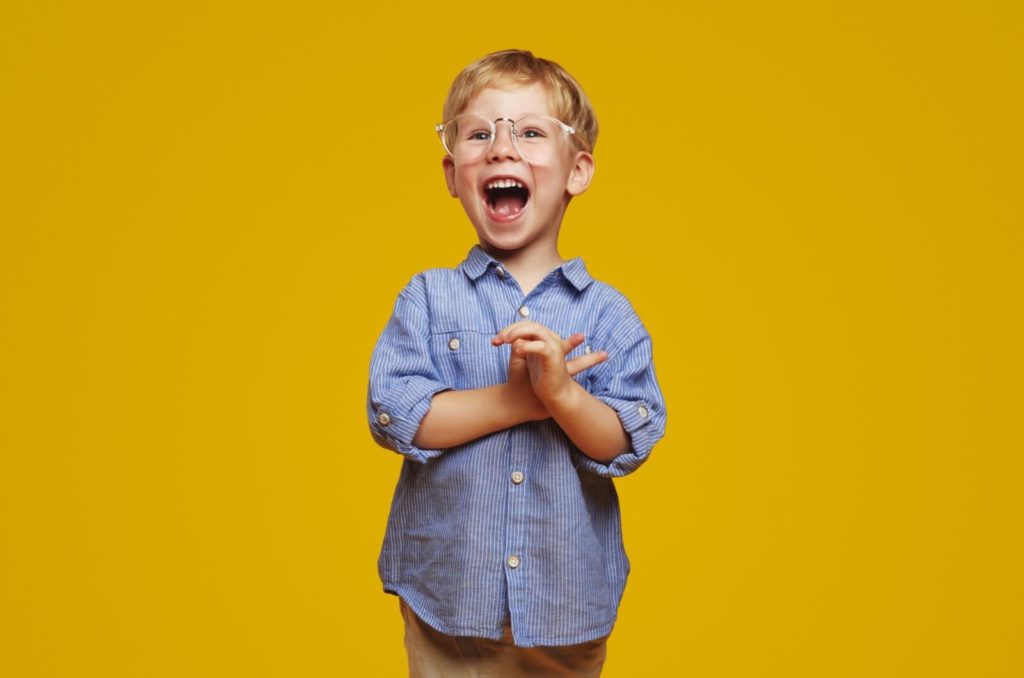 A happy and enthusiastic child enjoys wearing their myopia control glasses.