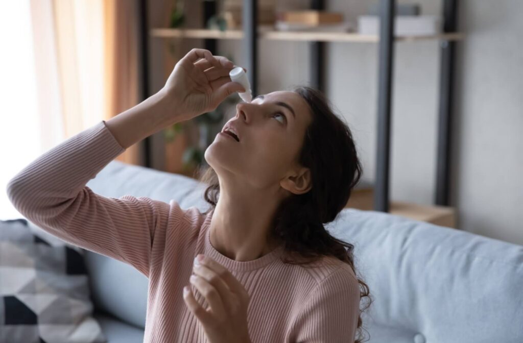 A person tilts their head back and applies eyedrops to treat their dry eye.