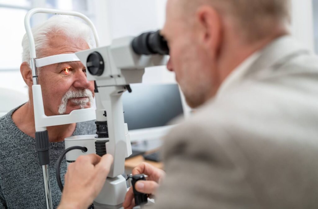 An optometrist examines an older adult's eyes for signs of eye disease during an exam.