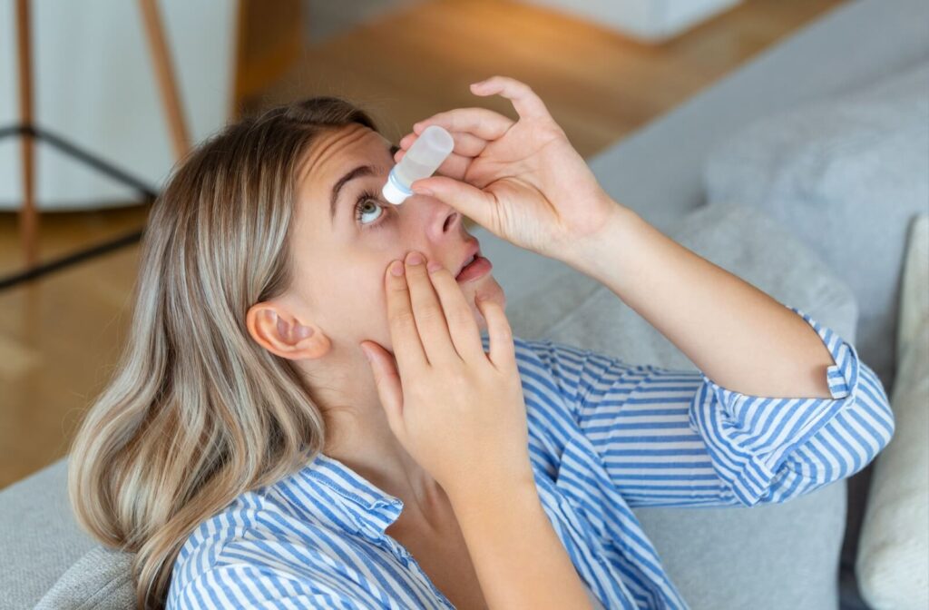 Woman applying eye drops at home to relieve dry eyes.